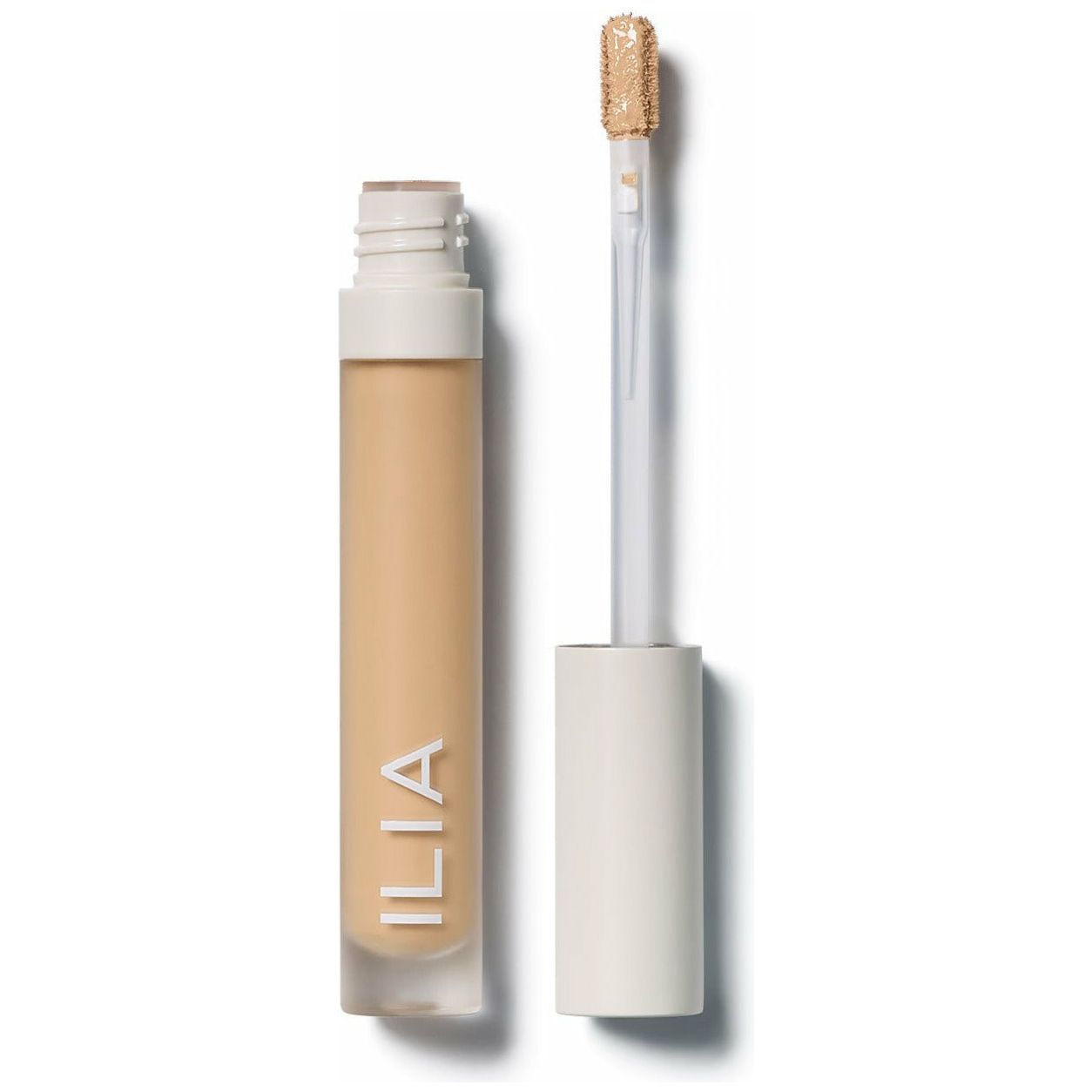 Concealer tube alongside its applicator wand.
