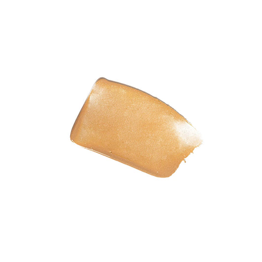 A swatch of liquid foundation makeup smeared on a white background.